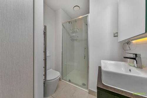 a bathroom with a shower and a toilet and a sink at QV Comfortable Downtown Apartment - 1136 in Auckland