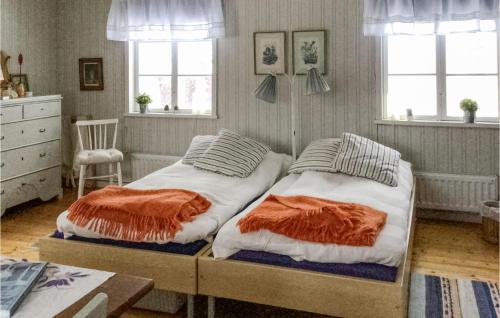 2 camas individuales en un dormitorio con ventanas y vestidor en Nice Home In Klubbcken With Sauna, 