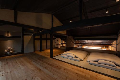 a room with two bunk beds and a wooden floor at 海野宿一棟貸し宿 上州屋 Unnojuku Joshuya in Tomi