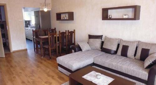 een woonkamer met een bank en een tafel bij Apartament Wiosenna in Malbork