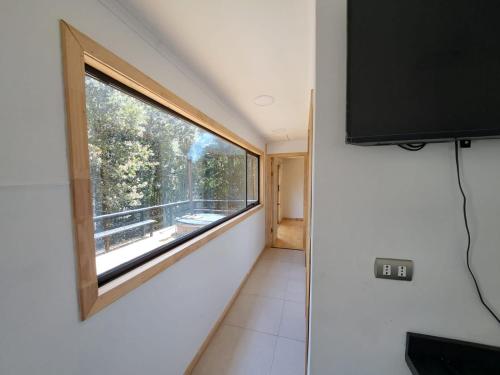 a small room with a window and a tv at Altos de Llicaldad Lodge in Castro