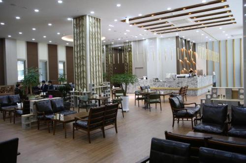 um restaurante com cadeiras e mesas e um bar em Benikea hotel seosan em Seosan