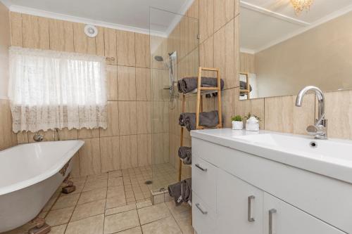 a bathroom with a tub and a sink and a bath tub at Stylish Lake Albert Cottage, Wagga Wagga in Wagga Wagga