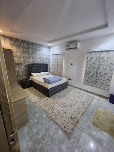 a large bedroom with a bed and a rug at Luxury 4 Bdr Home in the city in Abuja