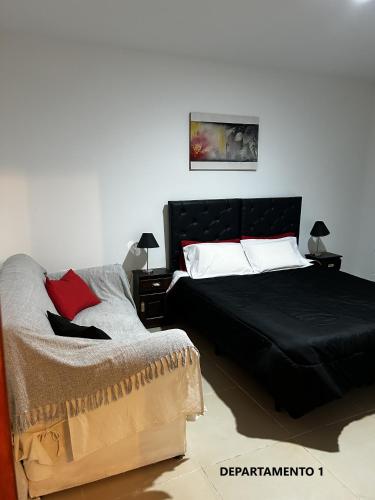 a bedroom with a bed with a black comforter at Sabattini Apart in Villa María