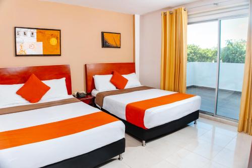 a hotel room with two beds and a window at Hotel Luxor Cúcuta in Cúcuta