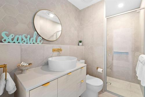 een badkamer met een wastafel en een spiegel bij Ohana Apartment 312 in Batemans Bay