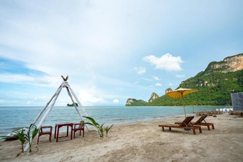 a group of chairs and an umbrella on a beach at Janpa Resort in Don Sak