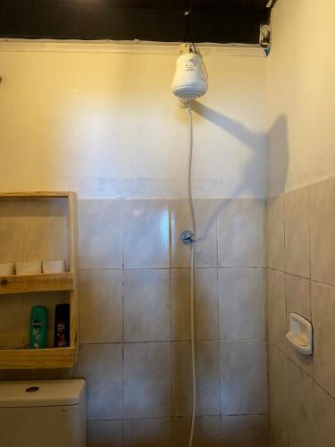 een badkamer met een douche met een licht aan de muur bij suite com vista mar in Salvador