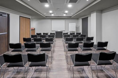 a conference room with chairs and a whiteboard at City Express by Marriott La Raza in Mexico City