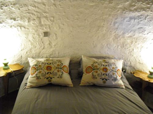 a bedroom with a bed with two pillows and two lamps at Moulin De Chez Renaud in Sousmoulins