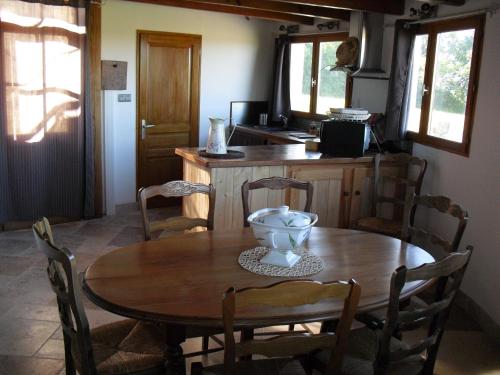 a wooden table and chairs in a kitchen with a table and a bowl at Moulin De Chez Renaud in Sousmoulins