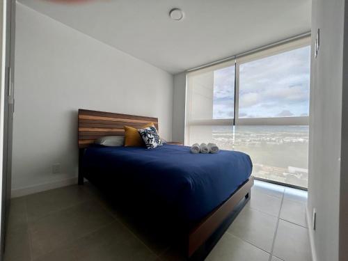 sypialnia z łóżkiem i dużym oknem w obiekcie COZY STUDIO near SABANA CENTRAL PARK w San José