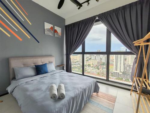 a bedroom with a bed with two towels on it at Modern Elegance Suite, 5 to 6 pax at Urban Suites Georgetown by SuperStay in Jelutong