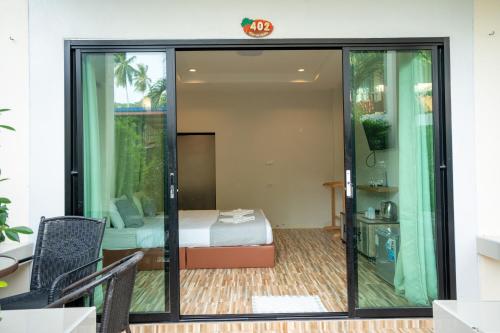 a room with a bed and a room with sliding glass doors at Janpa Resort in Don Sak