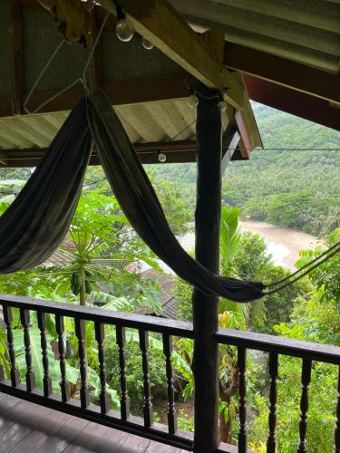 a view from the porch of a resort with a hammock at Silver cliff room 12 in Than Sadet Beach
