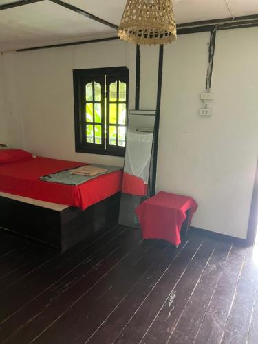 Than Sadet BeachにあるSilver cliff room 12の赤いベッドと窓が備わる客室です。