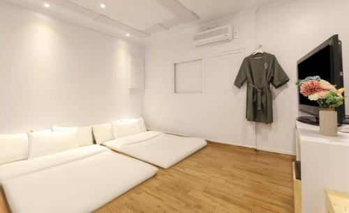 a living room with a white couch and a shirt on a wall at Gwanganri A Hotel in Busan