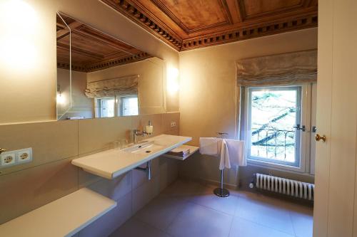 a bathroom with a sink and a mirror and a window at Schloss Englar in Appiano sulla Strada del Vino