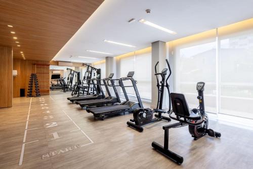 a gym with rows of treadmills and elliptical machines at Connect by LikeHome in Porto Alegre