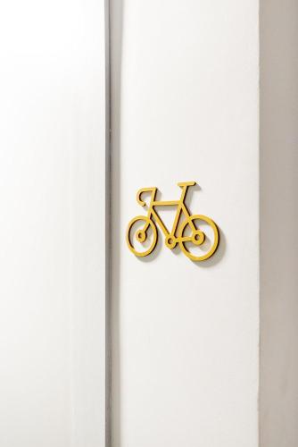 a gold bike sign on a white door at Connect by LikeHome in Porto Alegre