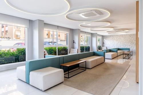 a lobby with a waiting room with couches and tables at Connect by LikeHome in Porto Alegre