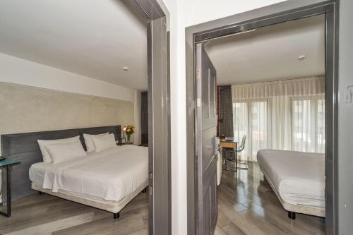 イスタンブールにあるFaros Hotel Taksim-Special Categoryのベッドルーム1室(ベッド2台付)、スライド式ガラスドアが備わります。
