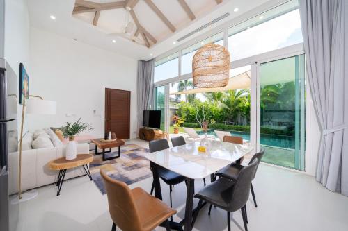 a living room with a dining table and chairs at Peykaa Estate Pool Villa by HCR in Phuket Town
