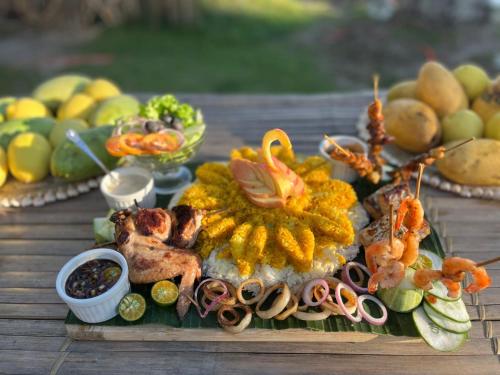 a plate of food with seafood and other foods on a table at On Board Panglao Beach Hostel & Resort in Dao