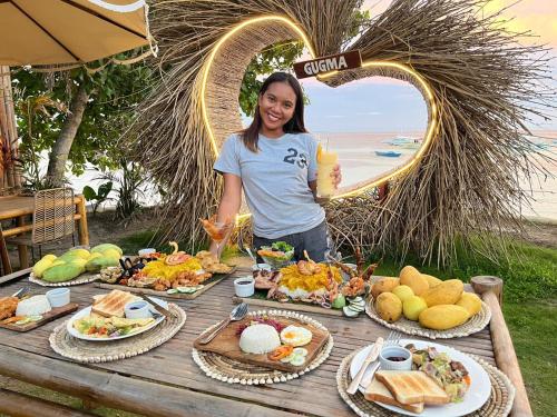a woman standing in front of a table of food at On Board Panglao Beach Hostel & Resort in Dao