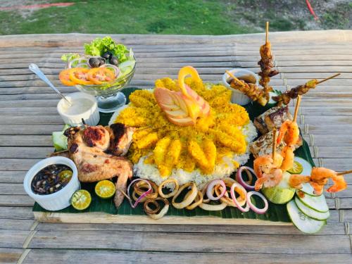 una bandeja de comida con marisco y verduras en una mesa en On Board Panglao Beach Hostel & Resort en Dao