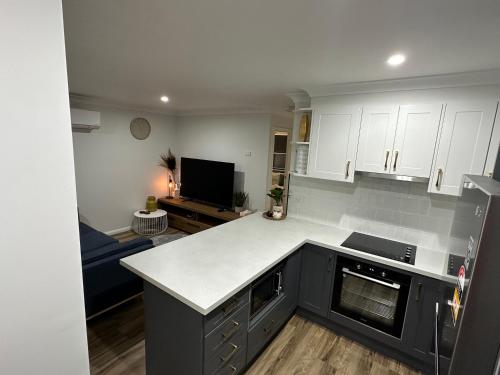 a kitchen with white cabinets and a counter top at Central Evans Wagga Apartments in Wagga Wagga