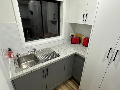 a kitchen counter with a sink and a window at Central Evans Wagga Apartments in Wagga Wagga