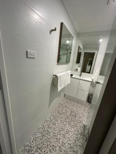 a bathroom with a shower and a sink and a mirror at Central Evans Wagga Apartments in Wagga Wagga