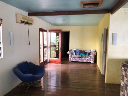 a living room with a blue chair and a couch at Limericks by the Sea in Savusavu