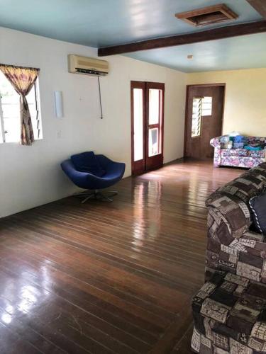 a room with a bed and a blue chair in it at Limericks by the Sea in Savusavu