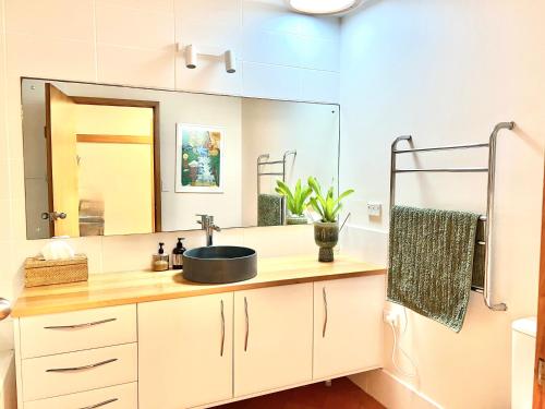 a bathroom with a sink and a mirror at Loloma! Luxe 4 bed, 2 bath Villa in Yamba