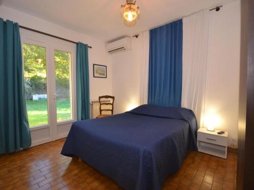 a bedroom with a blue bed and a window at Superb house with pool near the Luberon in Oppède