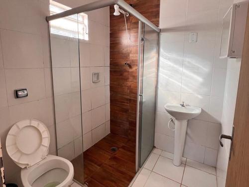 uma casa de banho com um chuveiro, um WC e um lavatório. em Sítio em Atibaia em Atibaia