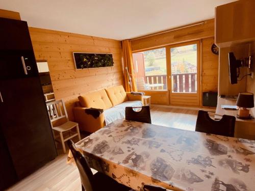 un salon avec une table et un canapé dans l'établissement Appartement moderne centre village avec balcon et garage - FR-1-459-222, à La Clusaz
