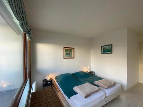 une chambre avec un lit avec une couverture bleue dans l'établissement Appartement rénové avec piscine, 4 pers, Capbreton - FR-1-413-230, à Capbreton