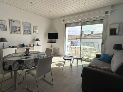 un salon avec une table et un canapé dans l'établissement Appartement cosy avec terrasse près du port - FR-1-224B-210, à Noirmoutier-en-l'lle