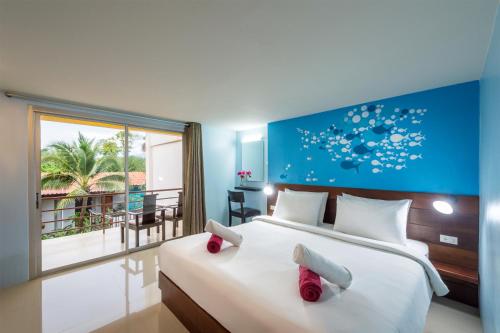 a bedroom with a large bed and a balcony at Lanta Thip House by Swiss-Belhotel - SHA Plus in Ko Lanta