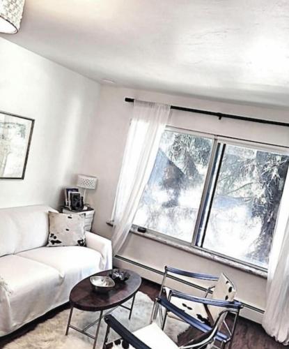 a living room with a white couch and a large window at Perfect Inside Downtown Aspen Location! Romantic 1300 ft, 4 Blocks or 396 m, to AJAX or Aspen Mountain in Aspen