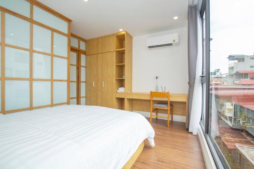 ハノイにあるSumitomo 14 Apartment - 50 Phan Ke Binh streetのベッドルーム1室(ベッド1台、デスク、窓付)