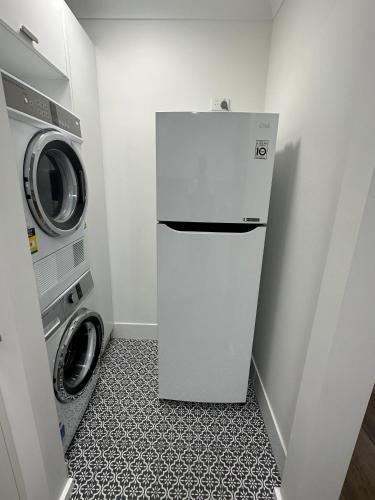 a white refrigerator next to a washing machine in a room at Central Evans Wagga Apartments in Wagga Wagga