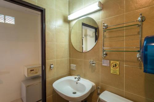 a bathroom with a sink and a mirror and a toilet at Lanta Thip House by Swiss-Belhotel - SHA Plus in Ko Lanta