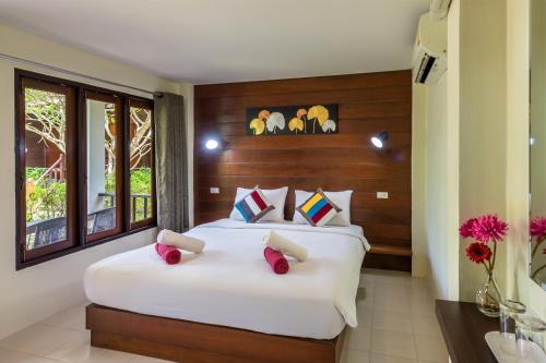 a bedroom with two beds with red pillows at Lanta Thip House by Swiss-Belhotel - SHA Plus in Ko Lanta