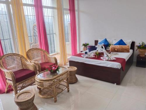 um quarto com uma cama, cadeiras e janelas em 4REST INN PRIVATE LIMITED em Kodaikanal