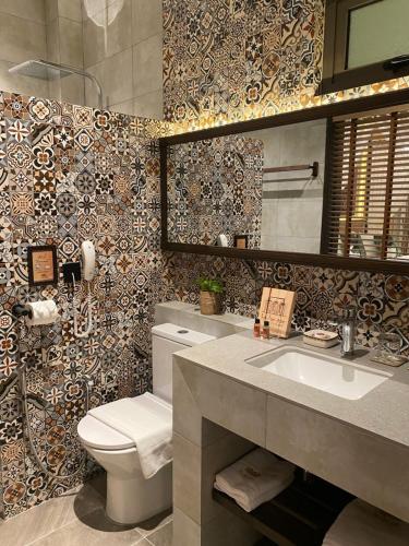 een badkamer met een toilet, een wastafel en een spiegel bij ke-lan-tan House in George Town